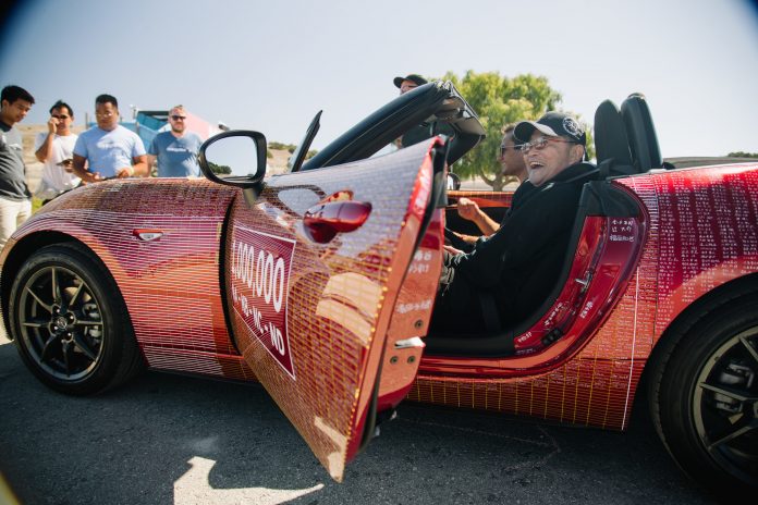 Former Mazda Design Chief Tom Matano enjoys riding in the one-millionth Mazda MX-5 built. The MX-5's last U.S. stop will be next week at the L.A. Auto Show