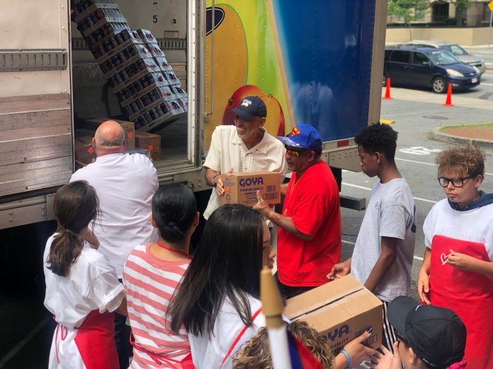 Goya and volunteers from the Puerto Rican Festival help to unload 2,500 pounds of food from the Goya truck to help feed the hungry in Massachusetts.